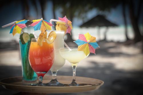 a tray with two cocktails and a vase with umbrellas at Cristal Resort in Paje