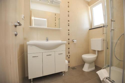a bathroom with a sink and a toilet at Apartmani Vrtlici Zdenka in Stara Novalja