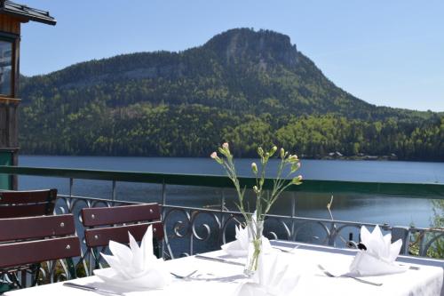 a table with a view of a lake and mountains at Hotel am See - Seeresidenz in Altaussee
