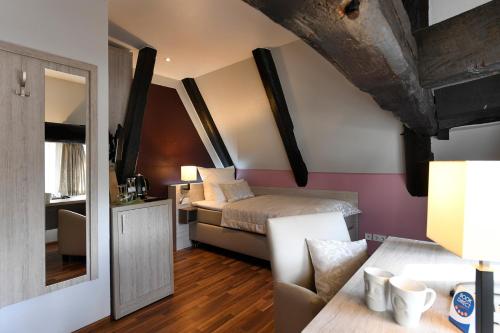 a small room with a bed and a mirror at Hotel Marktkieker in Großburgwedel