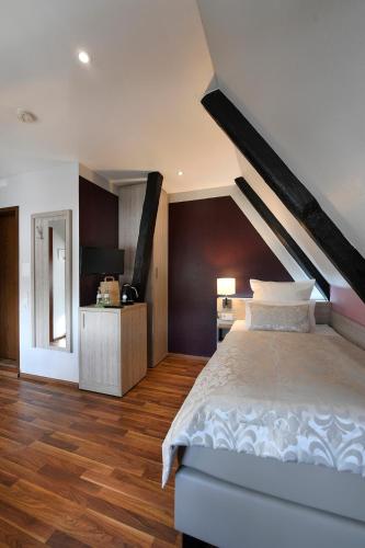 a bedroom with a large bed and wooden floors at Hotel Marktkieker in Großburgwedel