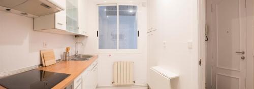 a white kitchen with a sink and a radiator at BALCON ENCIERRO! - El Mirador de la Cuesta de Santo Domingo in Pamplona