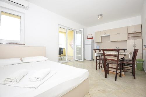 um quarto com uma cama, uma mesa e cadeiras em Apartmani Vrtlici Zdenka em Stara Novalja