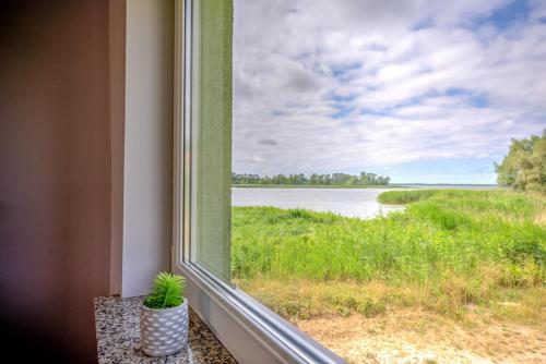 a window with a view of the water at Domki przy zalewie in Kamień Pomorski