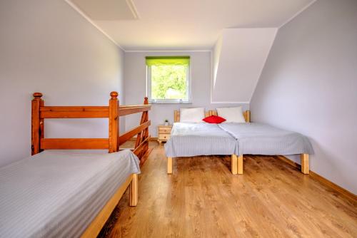 a bedroom with two bunk beds and a window at Domki przy zalewie in Kamień Pomorski