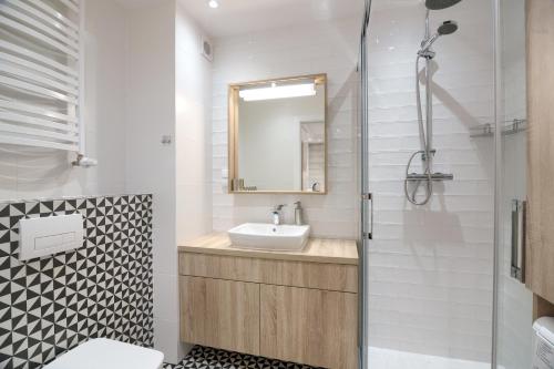 a bathroom with a sink and a shower at Apartament Rybakówka in Kołobrzeg