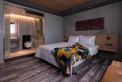 a bedroom with a large bed and a shower at Brio Hotel in Kaohsiung