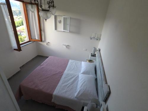 um quarto com uma cama num quarto branco em Casa della nonna Filò em Beverino