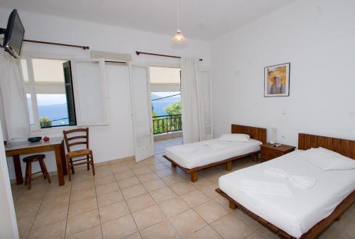a bedroom with two beds and a table and a desk at Soile Georgia in Loutra Edipsou