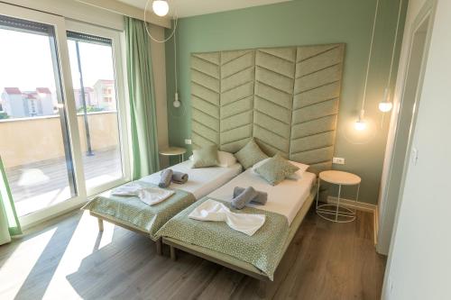 um quarto com uma cama e uma grande janela em Villa Sara - Private Infinity Pool em Novalja