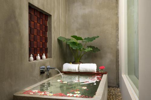 a bathroom with a tub with a koi pond at Sabara Angkor Resort & Spa in Siem Reap