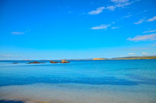 a large body of blue water with rocks in it at da mario e maria in Aglientu