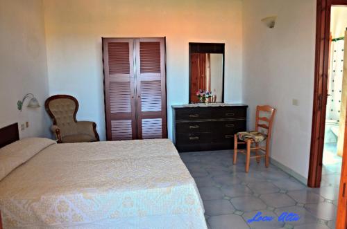 a bedroom with a bed and a dresser and chairs at da mario e maria in Aglientu