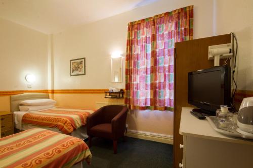 ブラックプールにあるBrooklands Over 50's Onlyのベッド2台、薄型テレビが備わるホテルルームです。