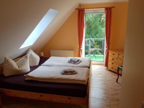 a bedroom with a bed and a large window at Twee Linden Nienhagen in Ostseebad Nienhagen