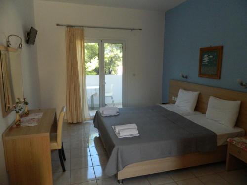 a bedroom with a bed and a table and a window at Asteri Studios in Skiathos
