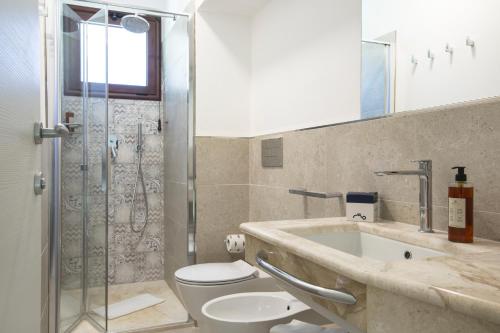 e bagno con lavandino, servizi igienici e doccia. di Cormoran Residence a Villasimius