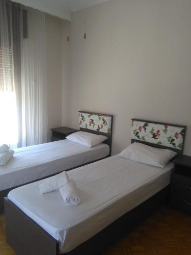 two beds sitting in a room with a window at Olena House in Kavala