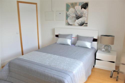 um quarto com uma cama com um edredão azul em Arco de Almedina Boutique em Coimbra