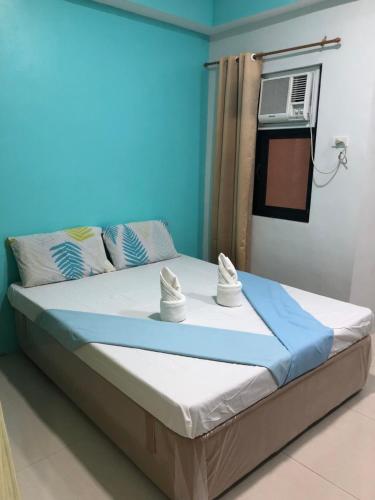 a bedroom with a large bed with a air conditioner at RF Suites in Cebu City