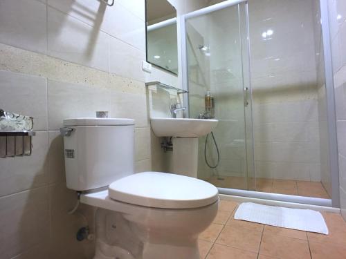 a bathroom with a toilet and a sink and a shower at Kenting Dio Inn in Hengchun