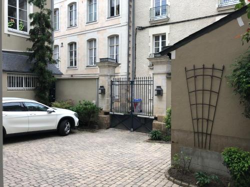 a white car parked in front of a building at La Maison D'Hôtes Nantes Centre in Nantes
