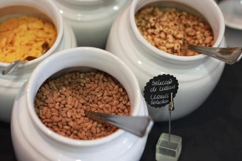 a table with three bowls of food and nuts at Real Marina Hotel & Spa in Olhão