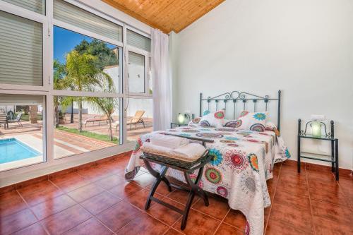 ein Schlafzimmer mit einem Bett und einem Pool in der Unterkunft La torre Casa rural in Fuente de Piedra