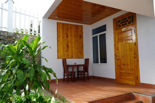 a small room with a table and a wooden door at Huy Trung Homestay in Bắc Hà