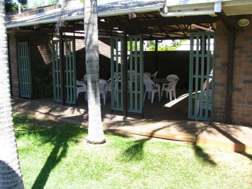 a patio with a table and chairs and a tree at Cattleman's Rest Motor Inn in Charters Towers