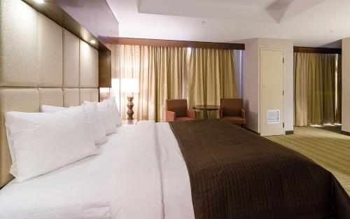 a large white bed in a hotel room at Hotel Casino New Nouveau Brunswick in Moncton