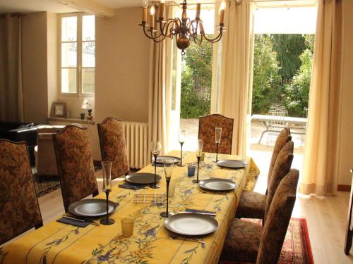 a dining room with a table and chairs and a large window at Elegant Family Home in Bouix in Bouix