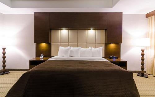 a large bed in a hotel room with two lamps at Hotel Casino New Nouveau Brunswick in Moncton