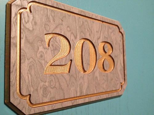 a wooden plaque with the number on a wall at Hotel Rivamare in Massignano