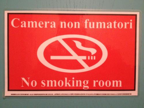 a red sign that says no smoking room at Hotel Rivamare in Massignano