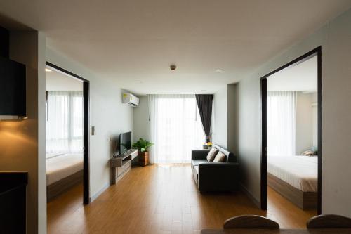 a living room with a couch and a bed and a mirror at ONPA Hotel & Residence Bangsaen in Bangsaen