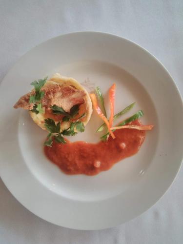 a white plate with a piece of food on it at Andasibe Lemurs Lodge in Andasibe