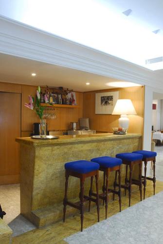 - un bar avec tabourets bleus dans la pièce dans l'établissement Reyes Católicos, à Séville