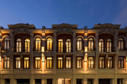 a large building with illuminated windows at night at Thomaz Palace in Porto