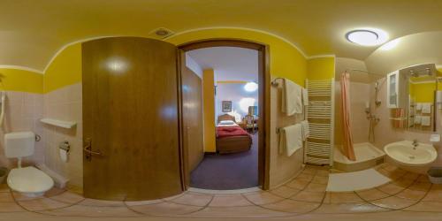 a bathroom with a hallway with a sink and a toilet at Hotel Garten in Slavonski Brod