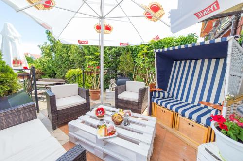 a patio with a table and chairs and an umbrella at Mister in Mielno