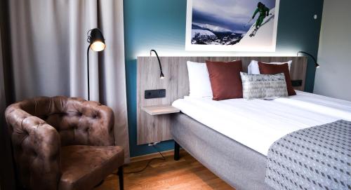 a hotel room with a bed and a chair at Nordfjord Hotell in Nordfjordeid