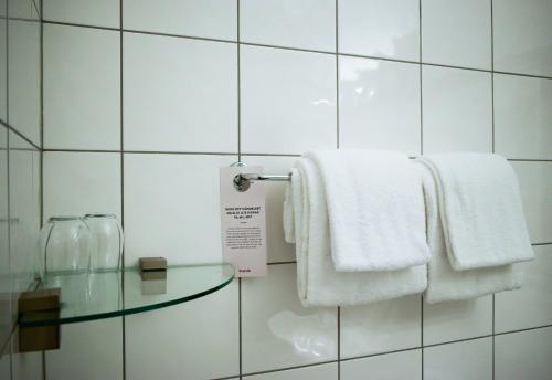 a bathroom with white towels and a glass table at Nordfjord Hotell in Nordfjordeid