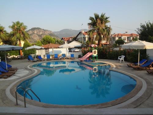 una piscina en un resort con sillas y sombrillas en Mavikosk, en Dalyan