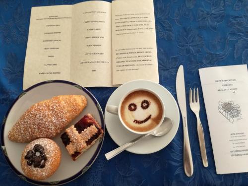 a table with a plate of food and a cup of coffee at Hotel Sangallo B&B in Montepulciano