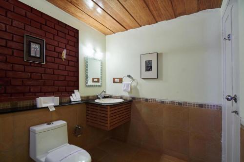 bagno con servizi igienici bianchi e lavandino di Ambady Estate a Munnar