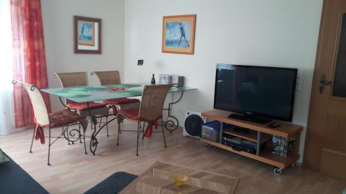 ein Wohnzimmer mit einem Tisch und einem TV in der Unterkunft Ferienwohnung Haller in Lahr