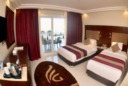 a hotel room with two beds and a balcony at Grand Ocean El Sokhna in Ain Sokhna