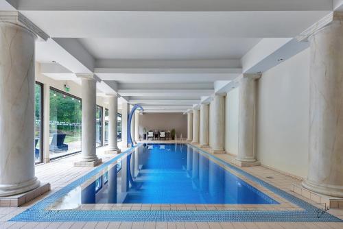 - une piscine avec colonnes et eau bleue dans l'établissement Nordfjord Hotell, à Nordfjordeid