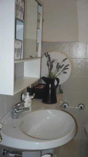 a bathroom with a sink and a vase with flowers at Trullo Mauro MGG - Trullo Fragale in Martina Franca